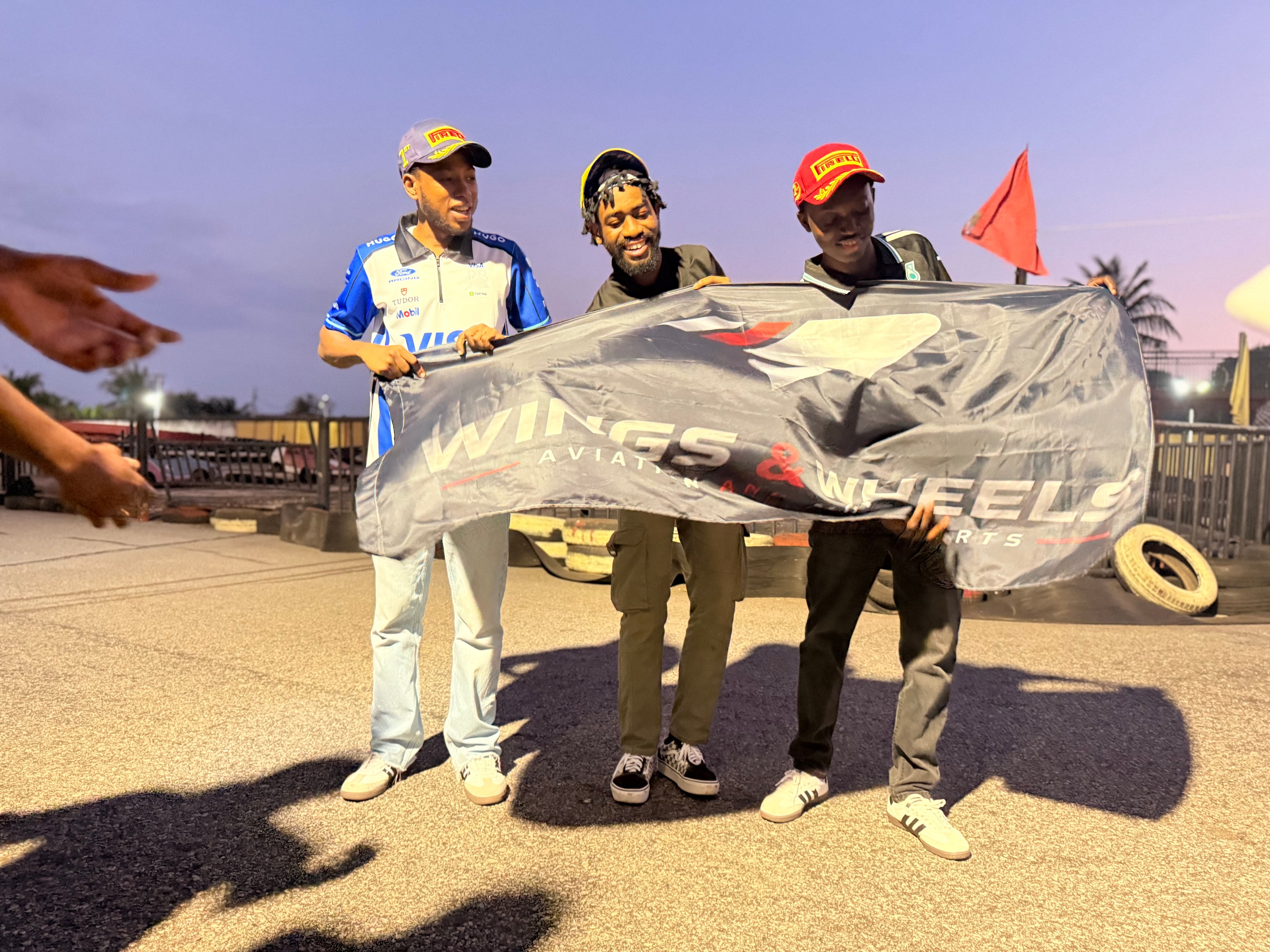 Wings & Wheels members holding the club banner